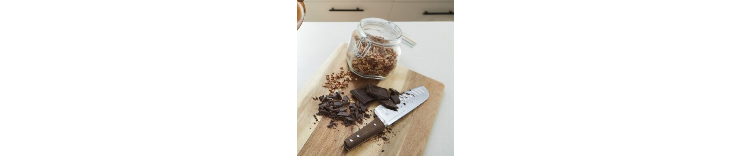 Chopped chocolate and nuts on a wooden cutting board