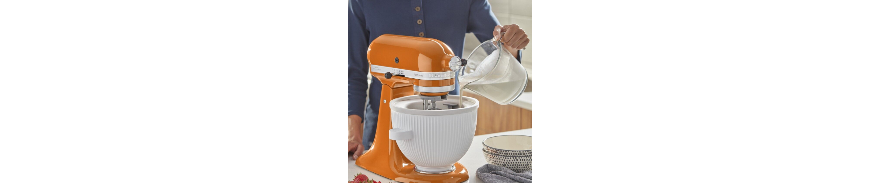 Person pouring cream into a KitchenAid® Ice Cream Maker Attachment