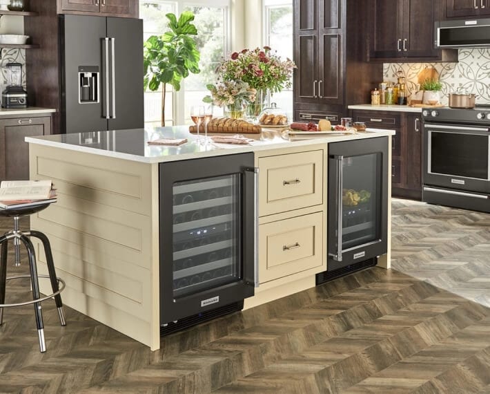A kitchen island with wine coolers installed underneath