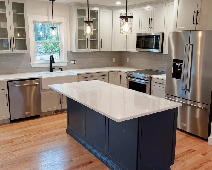 A white-topped kitchen island with darker cabinetry below
