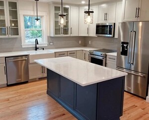 A white-topped kitchen island with darker cabinetry below