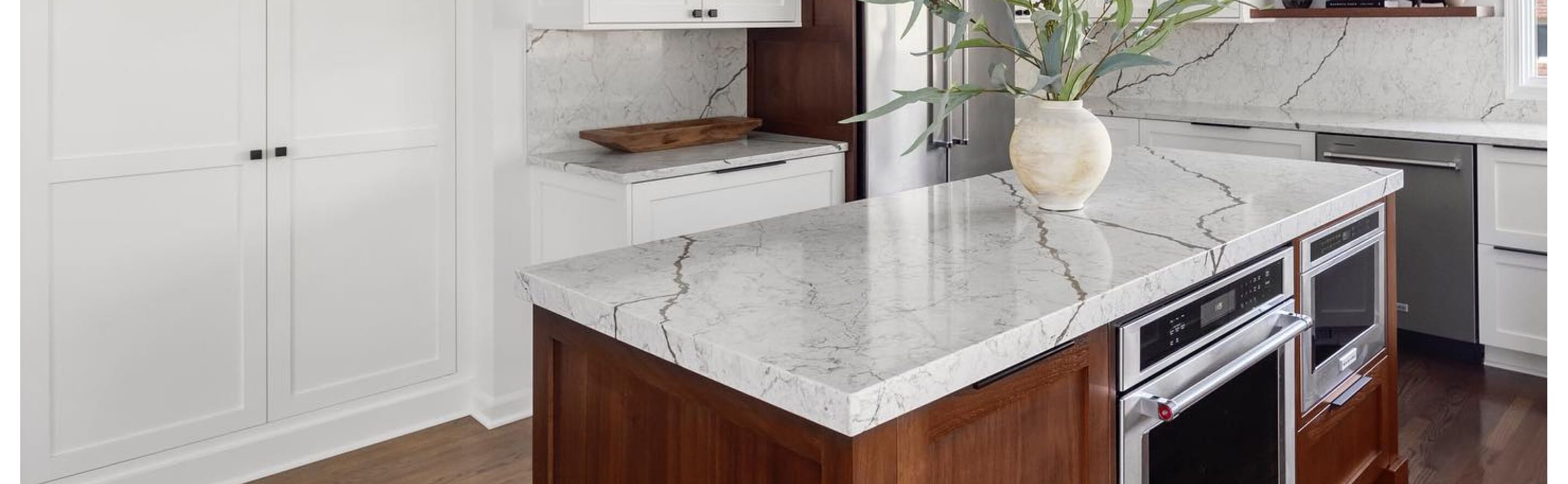A bright kitchen with a white, marble-like island