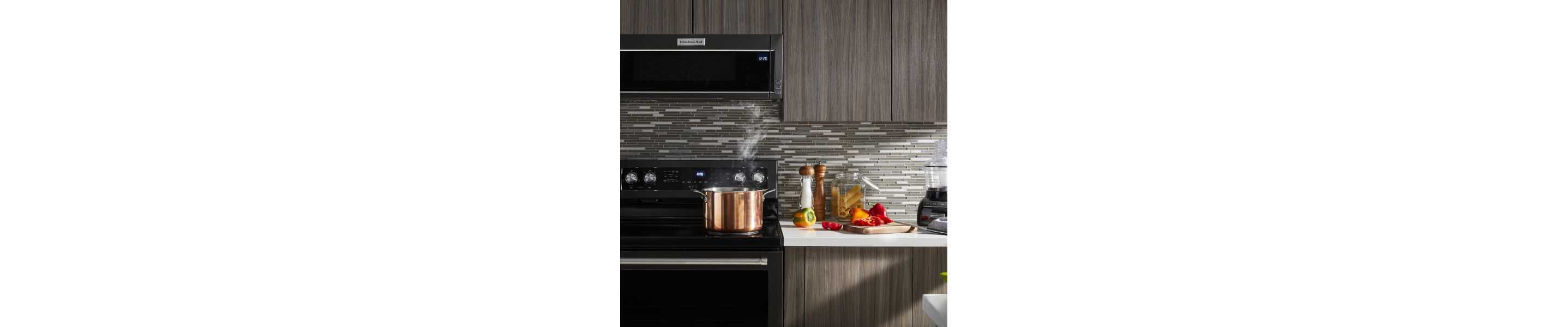 Stock pot heating on an electric stovetop below a KitchenAid® low profile microwave