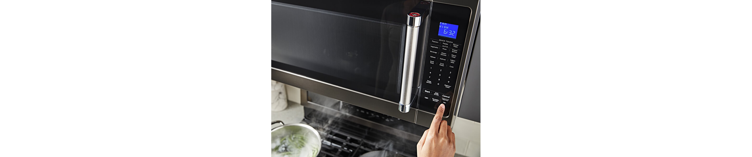 Person starting a cycle on a KitchenAid® microwave