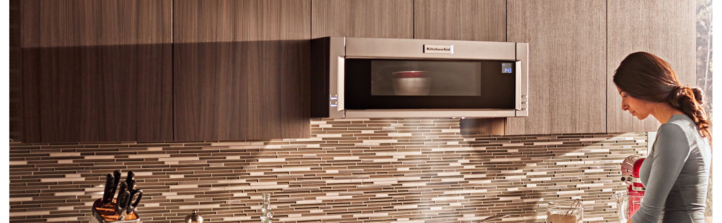 Person heating up food in a KitchenAid® microwave
