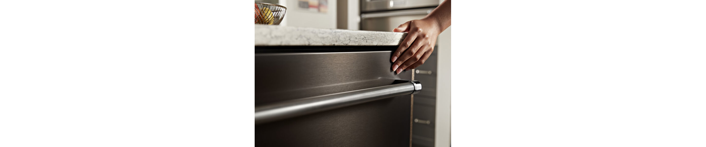 Hand touching the exterior of a sleek dishwasher