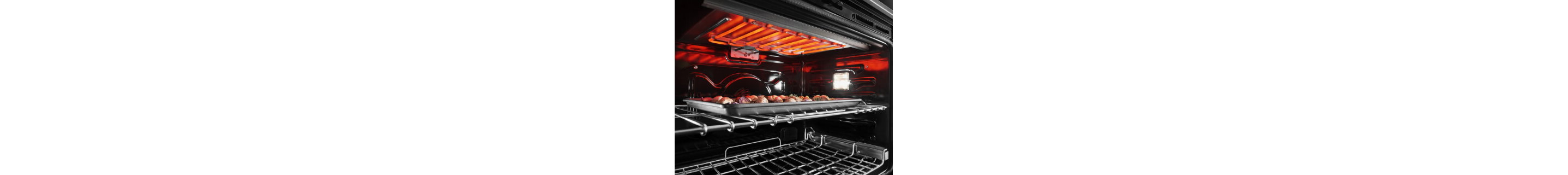 The inside of an oven range with the top burner hearing and a tray on the top rack