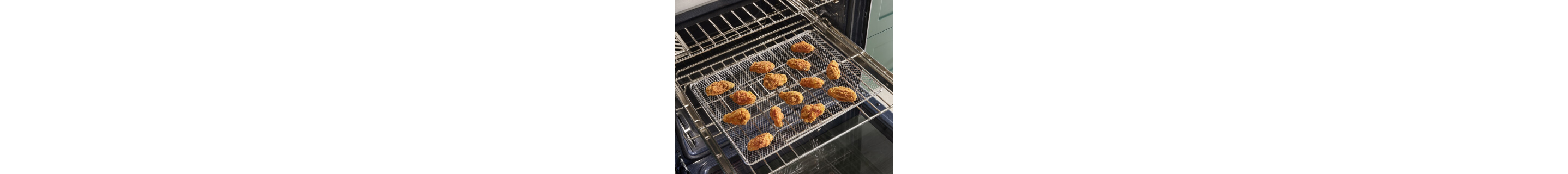 Chicken fingers on an air fry pan resting on an oven rack inside the range