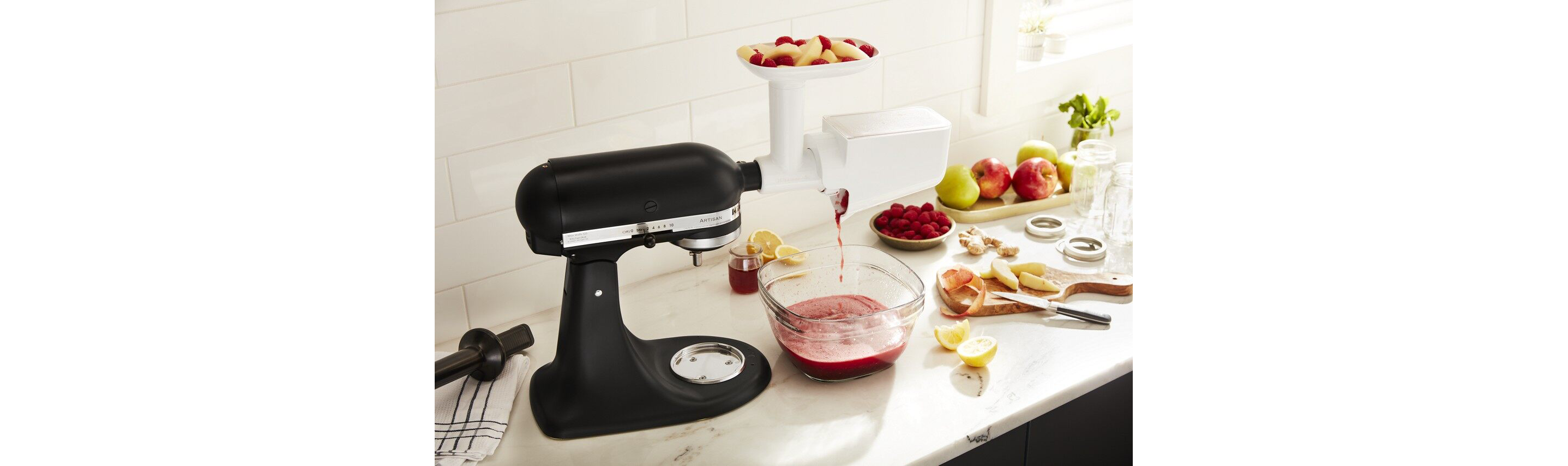 kitchenaid® fruit and vegetable strainer attachment on black stand mixer pureeing fruit