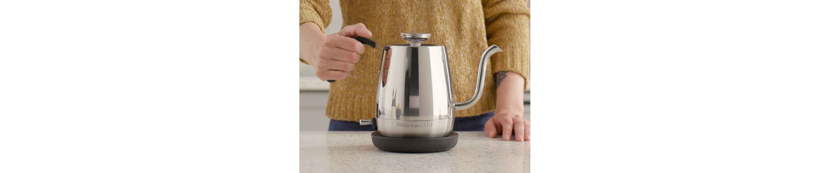 Maker holding on to handle for silver KitchenAid® gooseneck electric kettle
