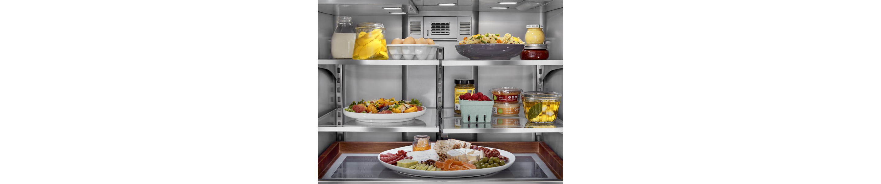 Interior of refrigerator with platters and side dishes organized inside
