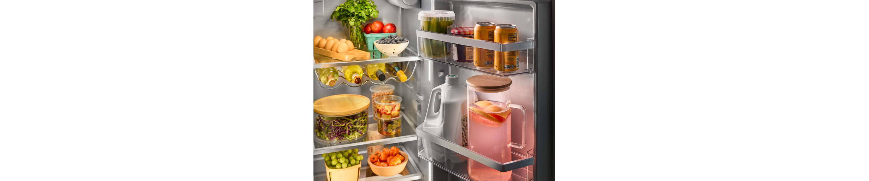 Beverages in door compartment of refrigerator stocked with fresh foods