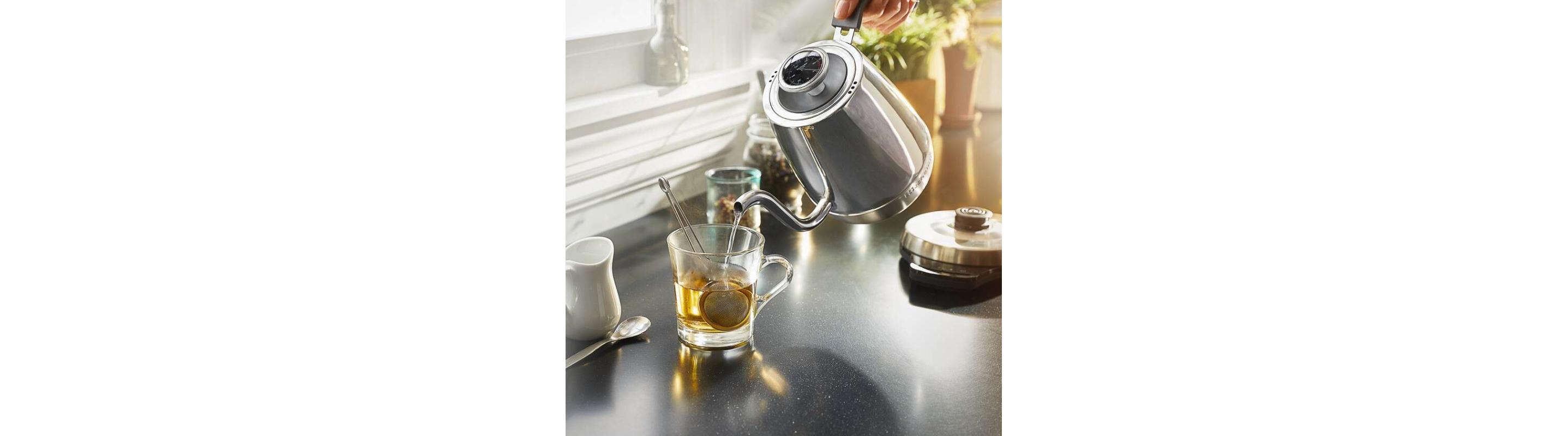 Gooseneck kettle pouring water into a mug of tea
