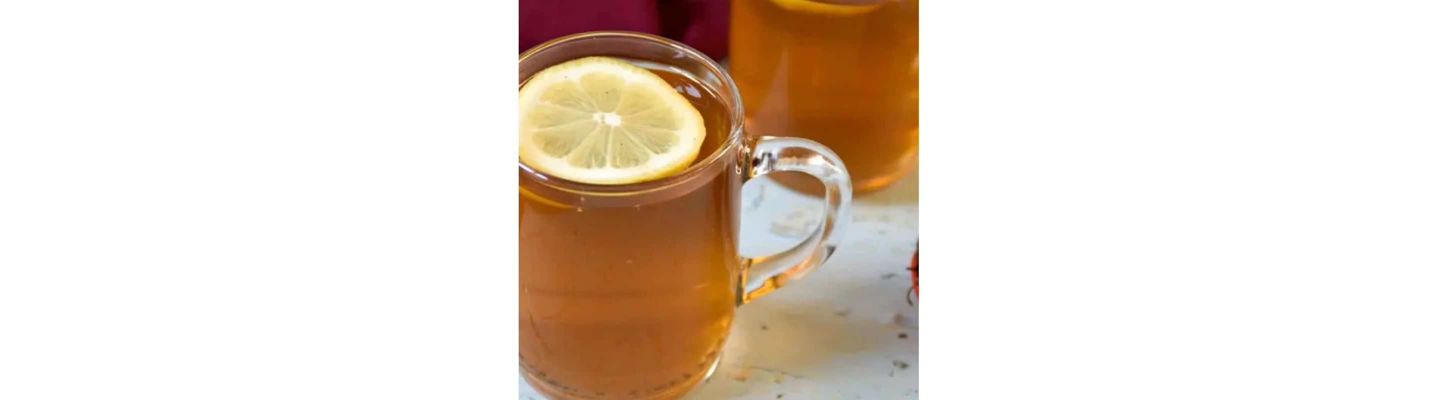 Glass mug of tea topped with a lemon slice