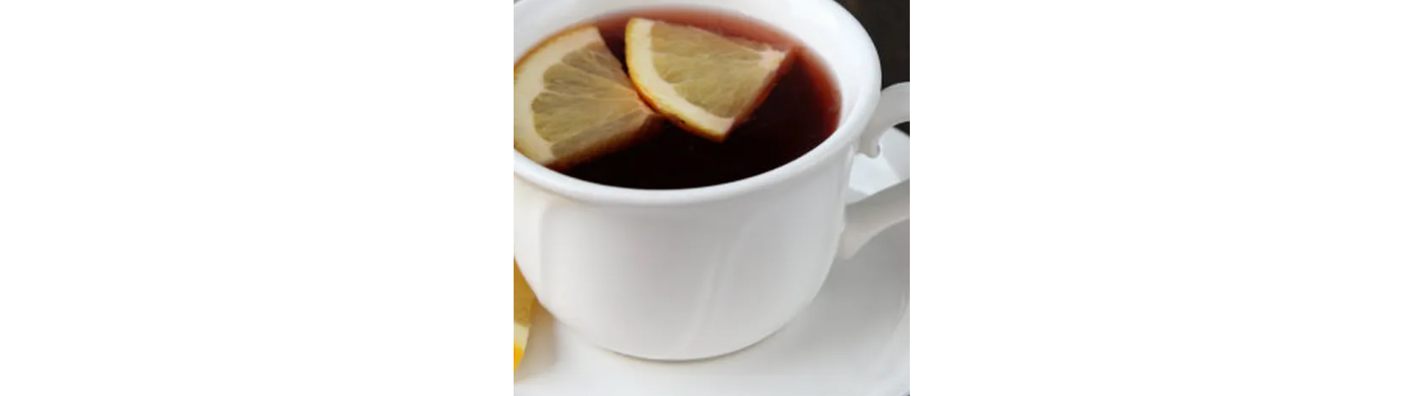 Cup of tea topped with two lemon wedges