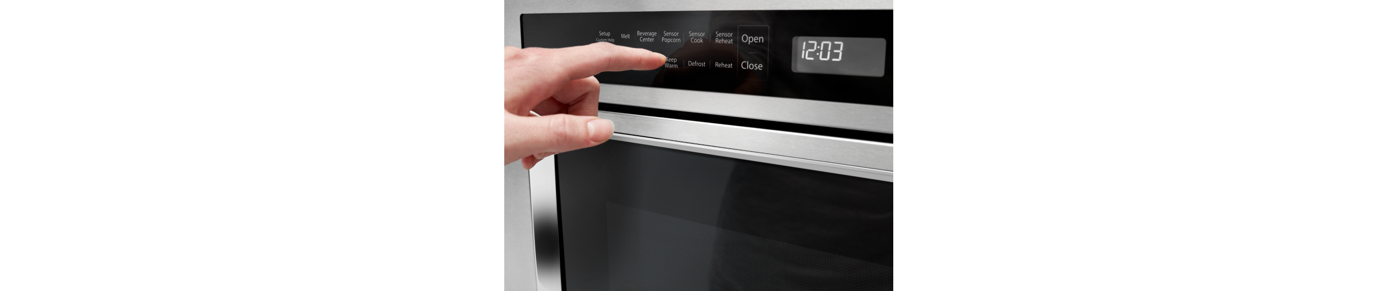 A person programming a setting on a KitchenAid® microwave.