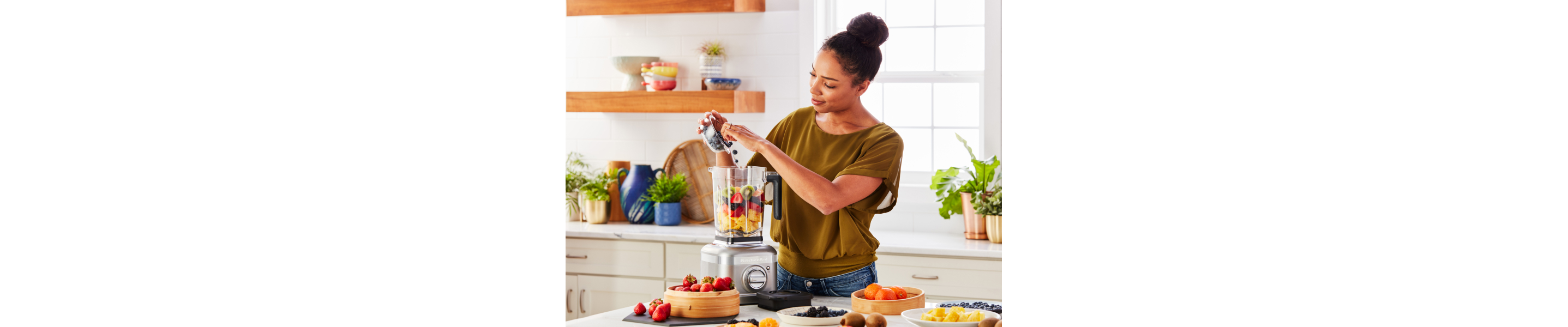 Person blending fruit in KitchenAid® blender 
