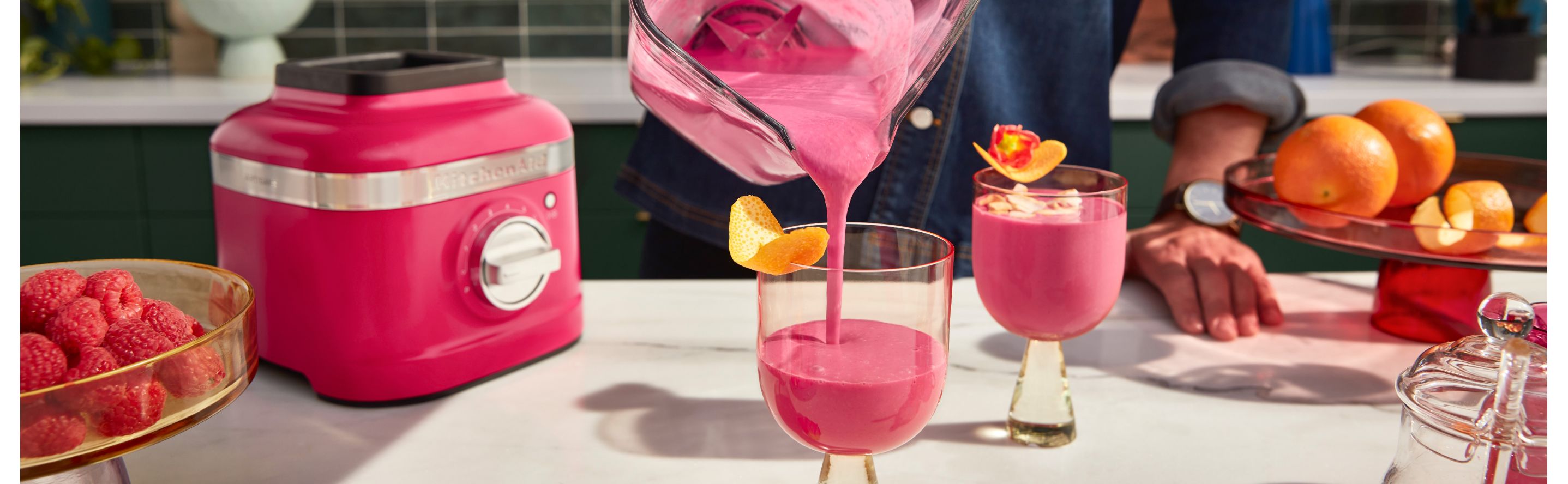 Frozen pink cocktails being poured from blender to glass