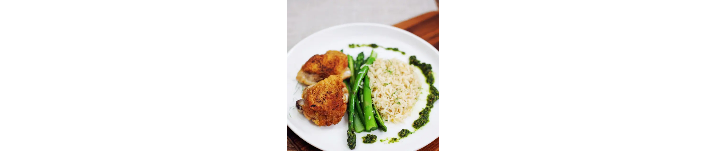Chicken, asparagus and freekah on a plate.