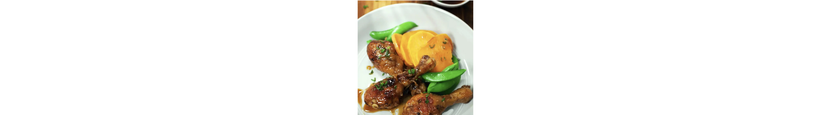 A plate of roasted chicken legs with spicy maple glaze
