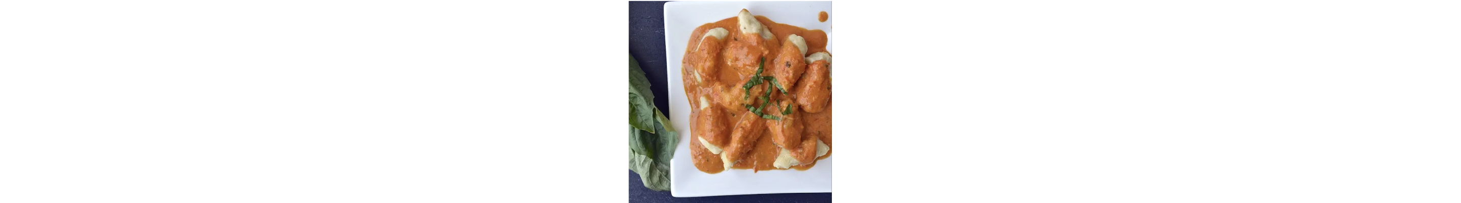 A plate of chicken covered in fresh tomato vodka sauce