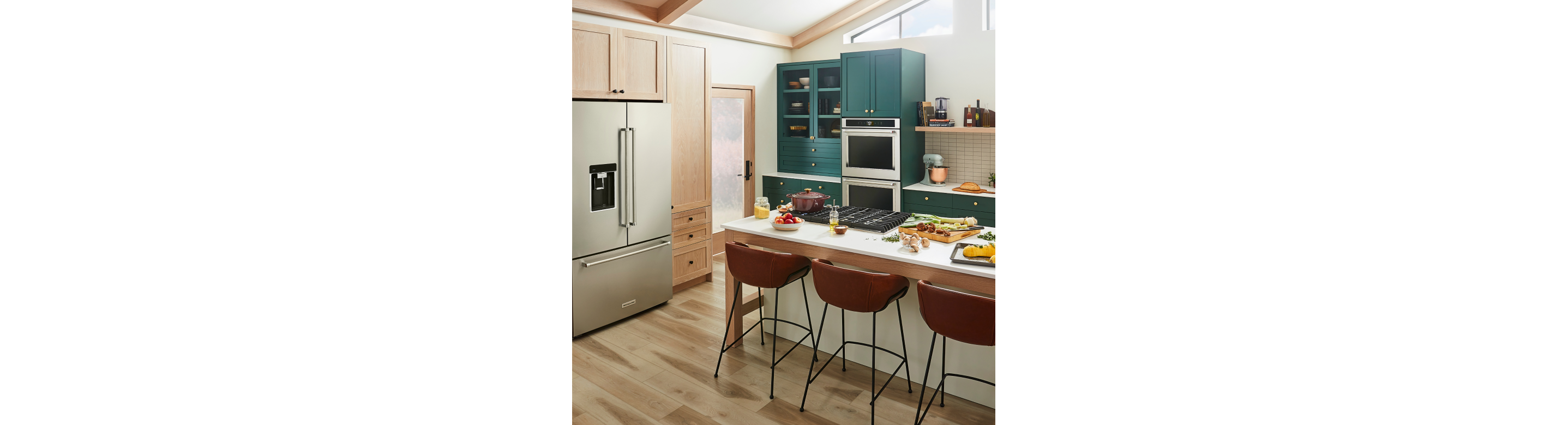 A trendy kitchen with teal cabinetry and a suite of KitchenAid® appliances.