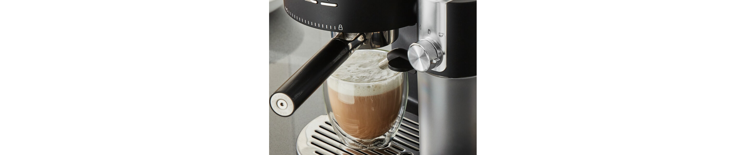 Cappuccino with foam resting on cup holder of espresso machine