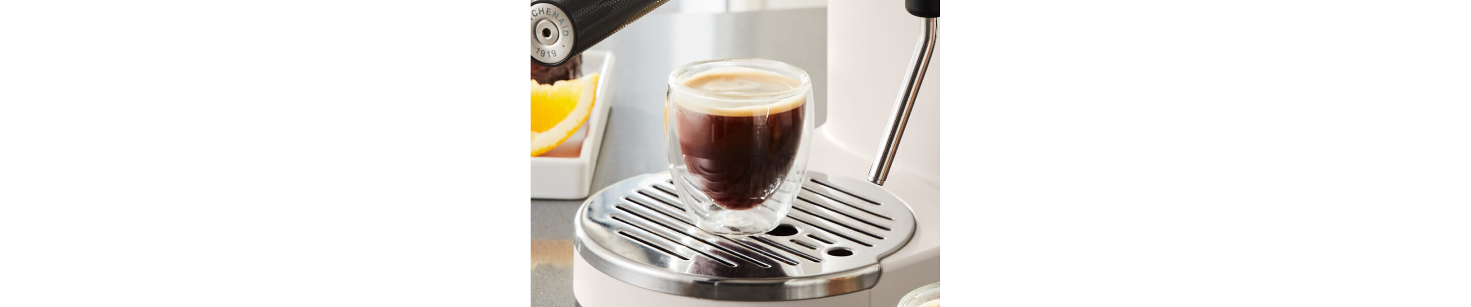 Finished espresso drink resting on cup holder of espresso machine