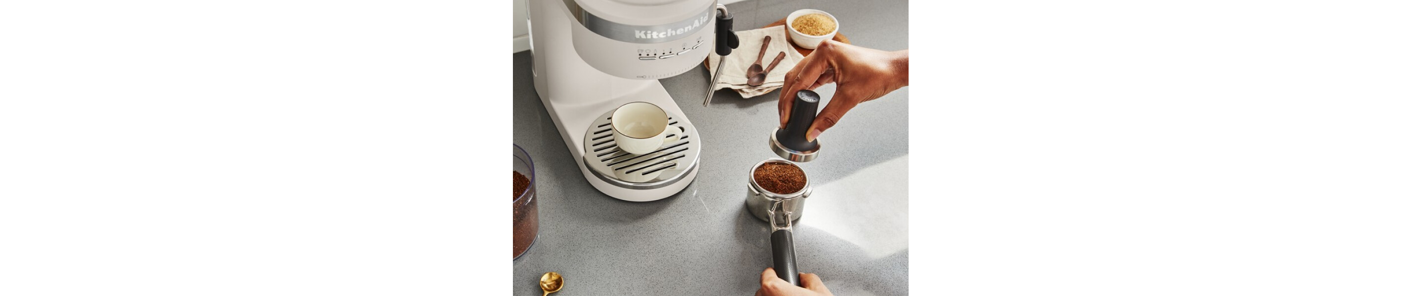 Person tamping down coffee grounds in portafilter of espresso machine