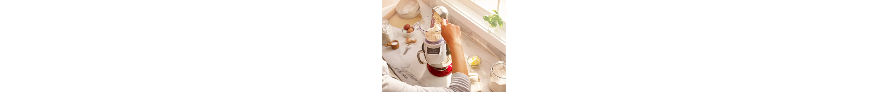 Person adding flour to the KitchenAid® Sifter + Scale attachment