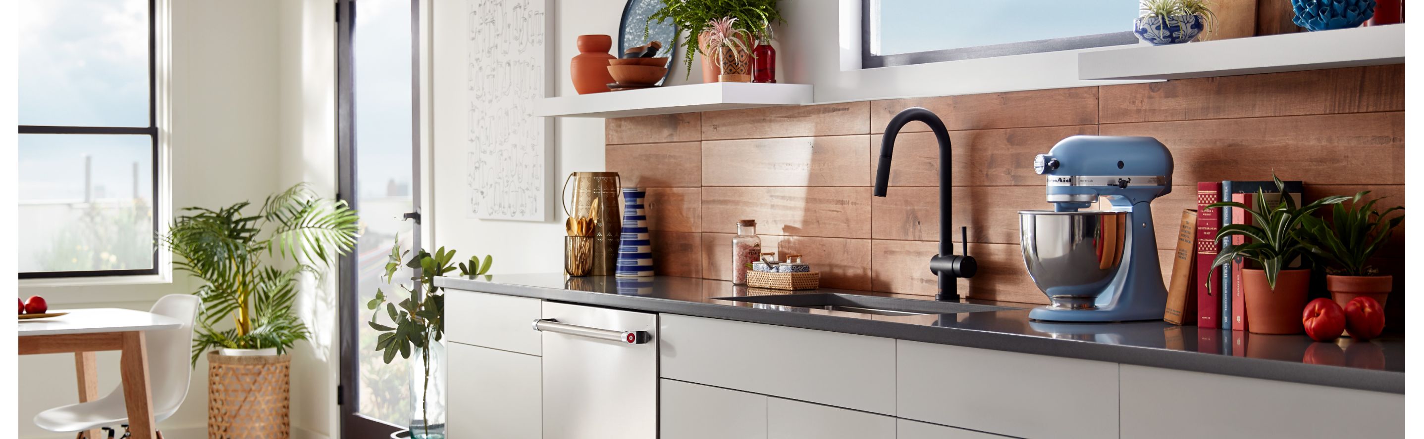 Blue KitchenAid® stand mixer on countertop with wood panel backsplash