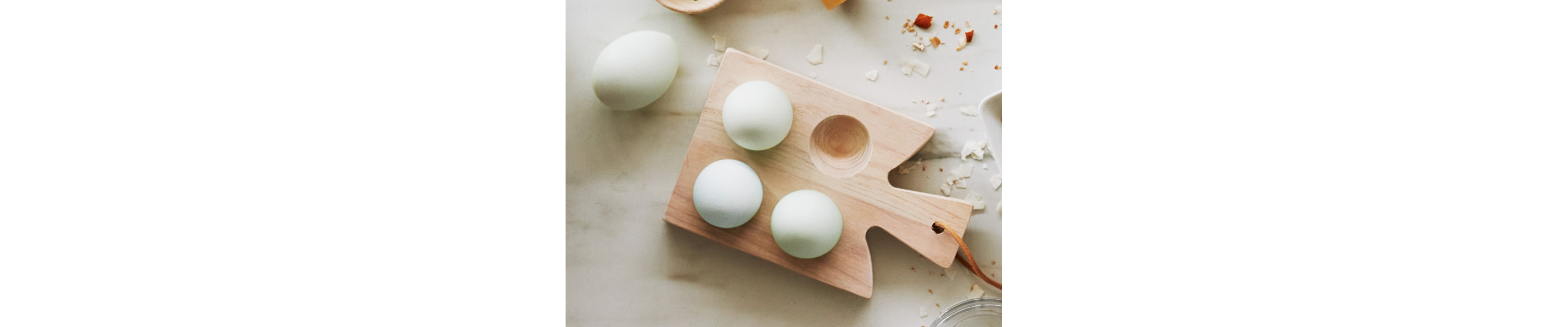 Four eggs on a wooden platter