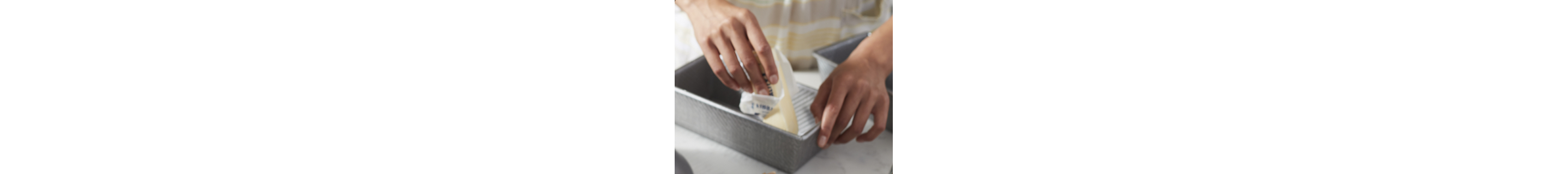 A person buttering a bread pan