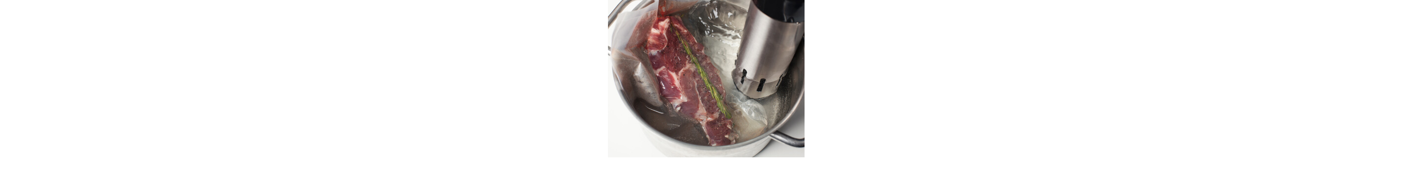 Piece of meat seasoned with rosemary in water with circulator tool in it