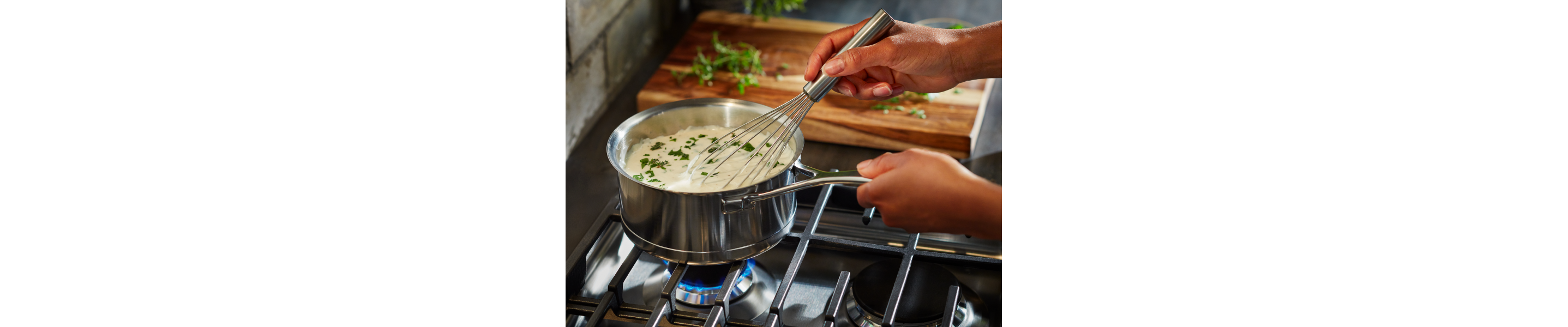 Person whisking soup on a gas stovetop 