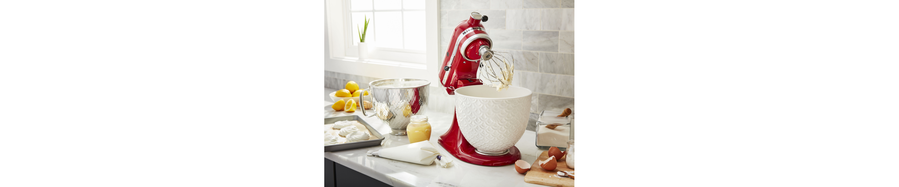 Red KitchenAid® stand mixer next to a tray of pastry dough