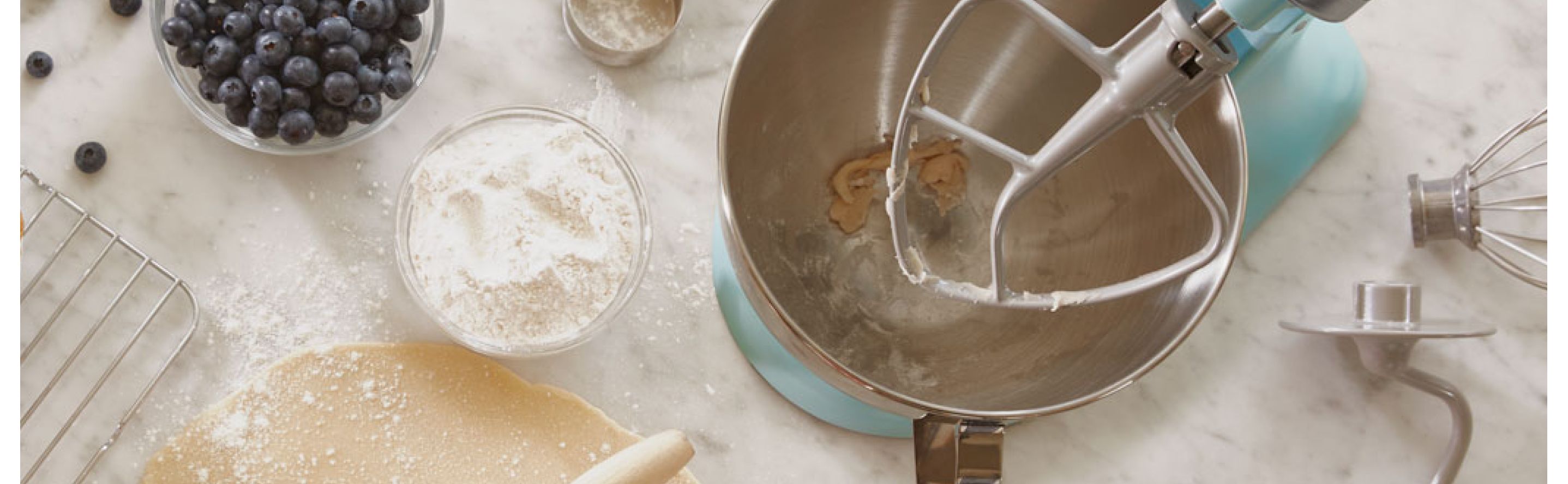 Blue KitchenAid® stand mixer next to pastry ingredients