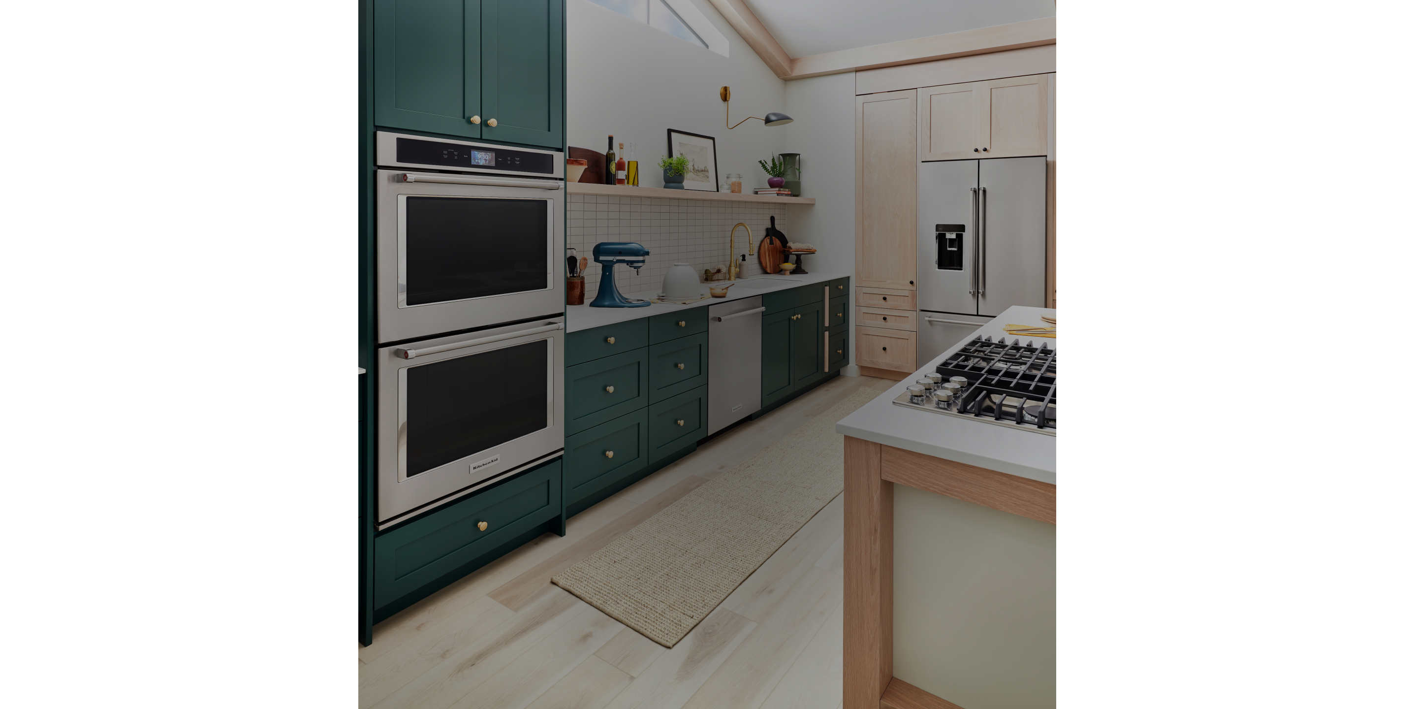 A kitchen with green cabinets and KitchenAid® appliances.