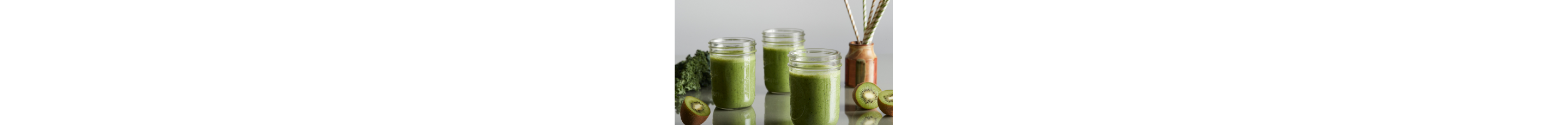 Green smoothies in jars surrounded by kiwis.