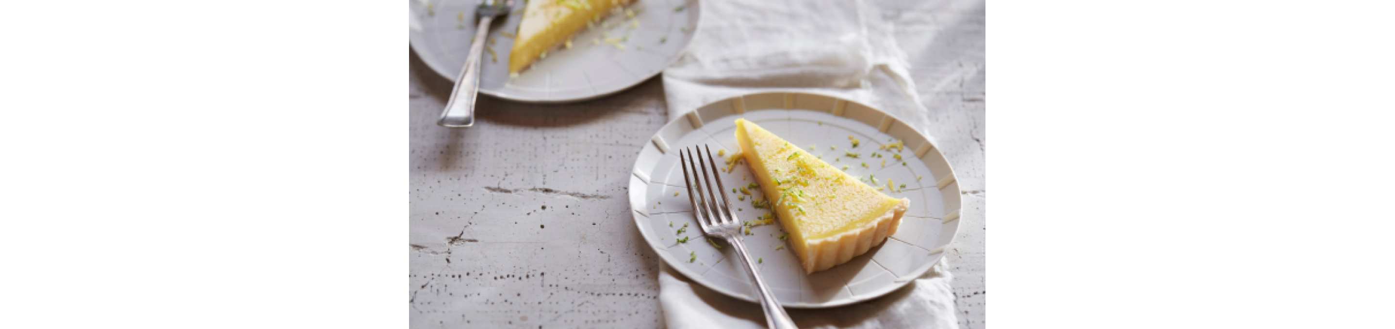 A slice of key lime pie on a white plate with a fork.