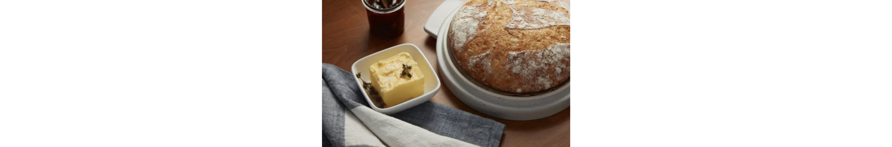 Butter next to a boule of bread.