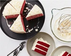 A sliced red velvet cake on a black serving tray