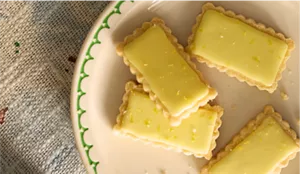 Four shortbread cookies glazed in a pale yellow yuzu glaze.