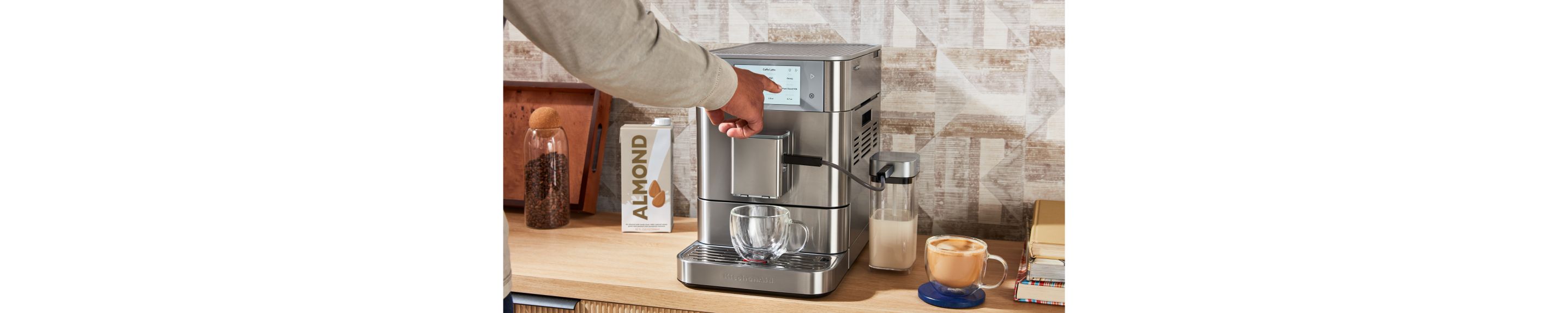 A person interacting with the touchscreen of a fully automatic espresso machine.