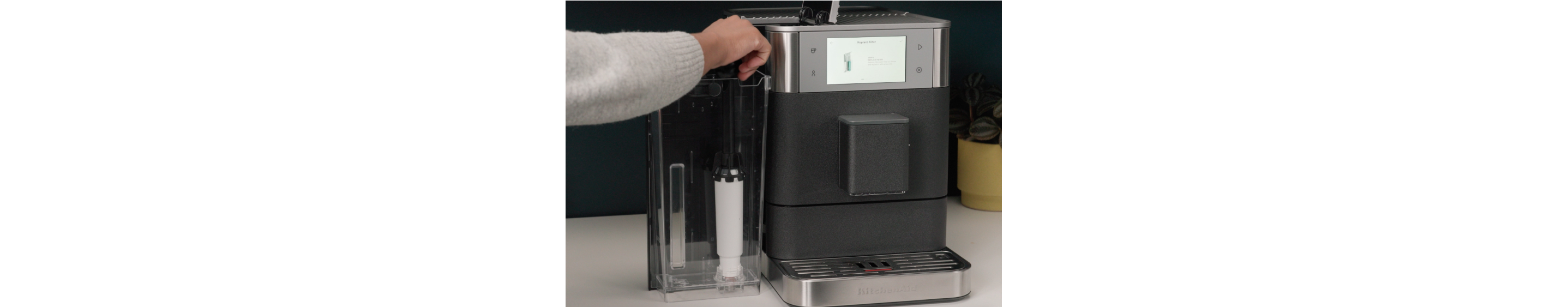 Person changing the water filter from an espresso machine