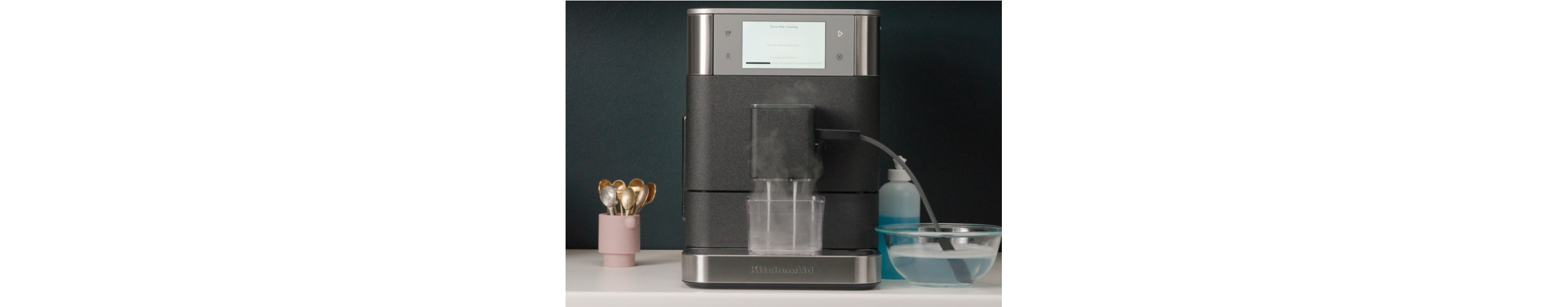 Espresso machine frother and wand being cleaned automatically