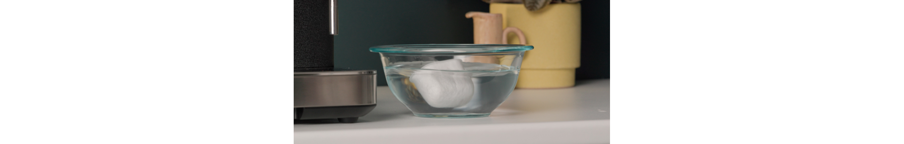 Espresso machine filter soaking in a bowl of water