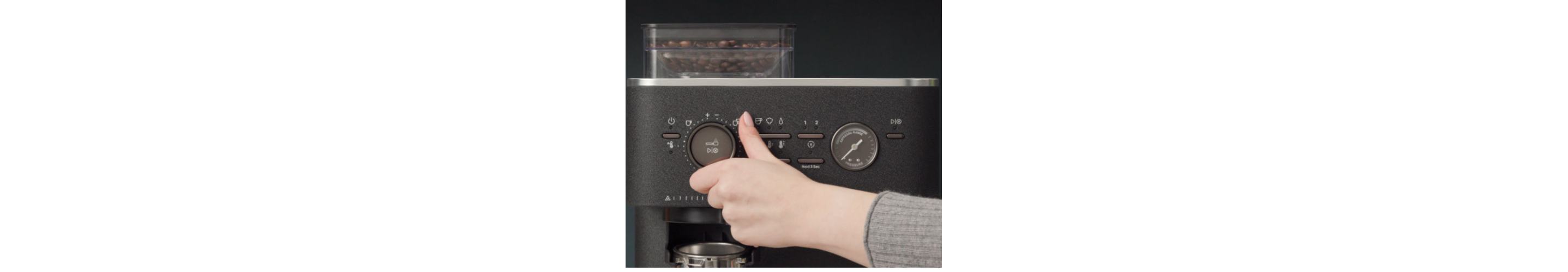 Person adjusting a dial on an espresso machine