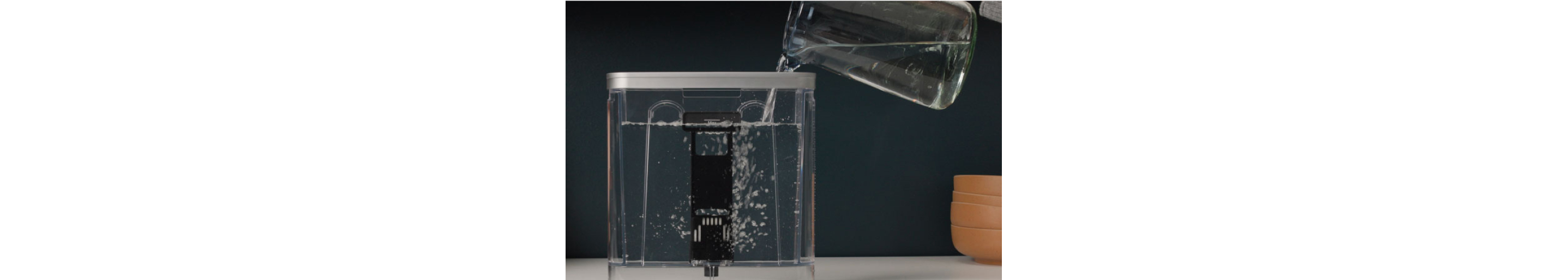 Water being poured inside of an espresso machine's water tank