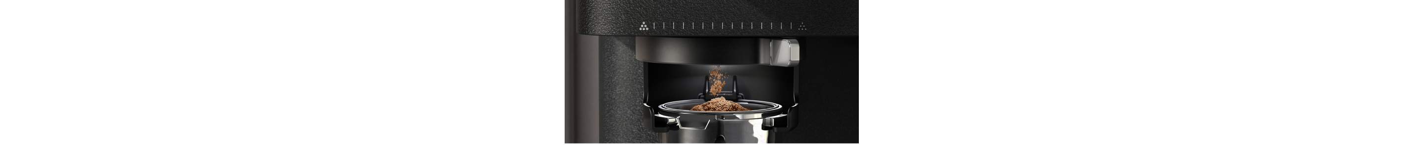 Closeup of espresso grinds pouring into a portafilter